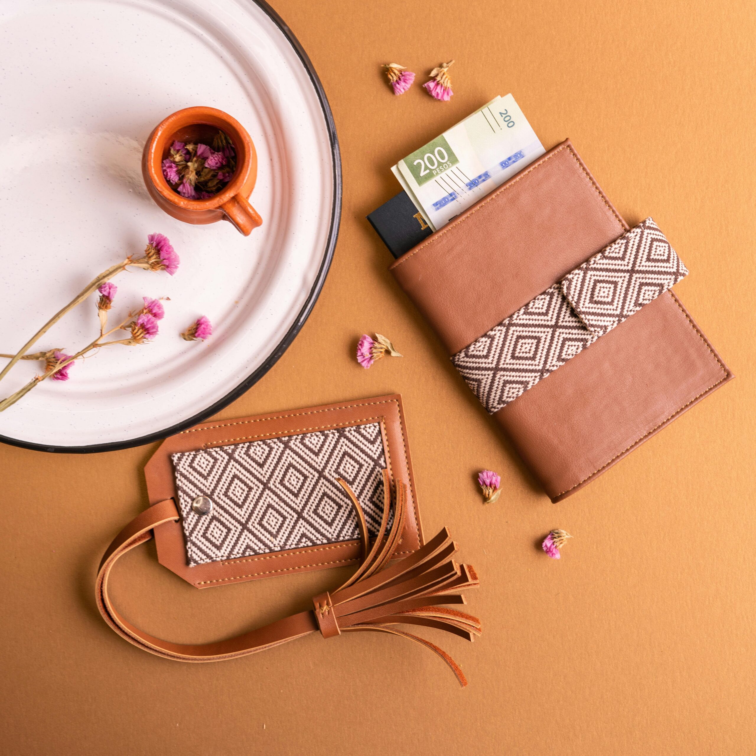 Top view of leather accessories and flowers on a brown background, capturing an elegant and minimalist style.